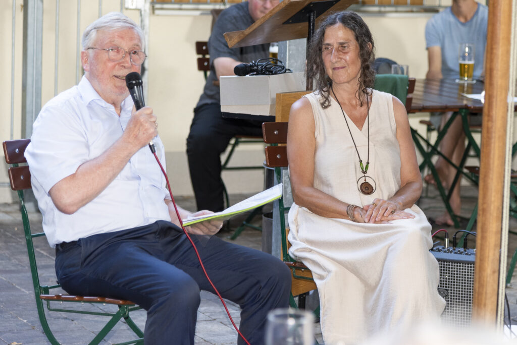 Ein Mann mit Mikrofon im Gespräch mit einer Frau bei der Präsentation des 15. Vitusbach.